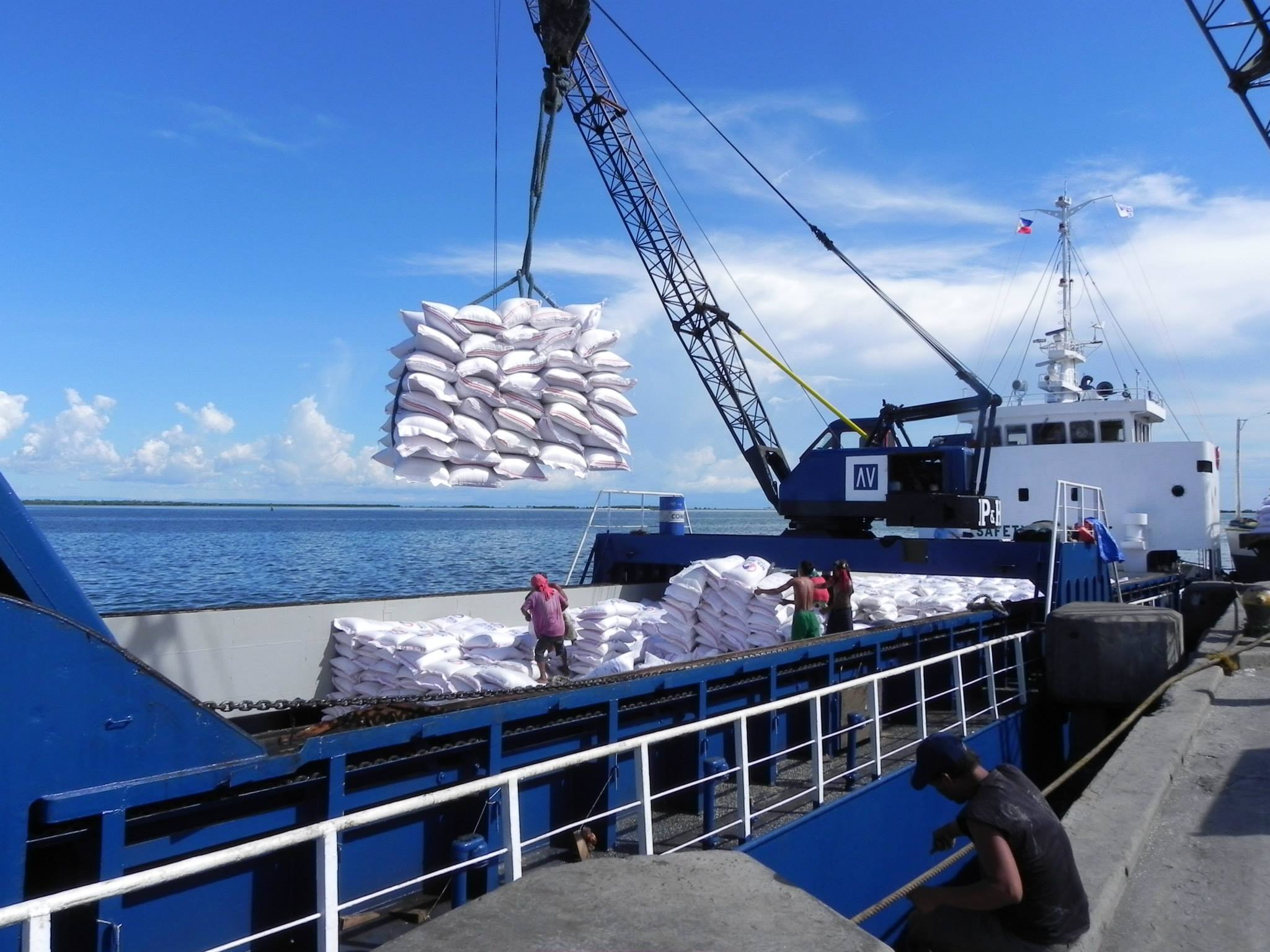 Cargo vessel being loaded with crane assistance at a port